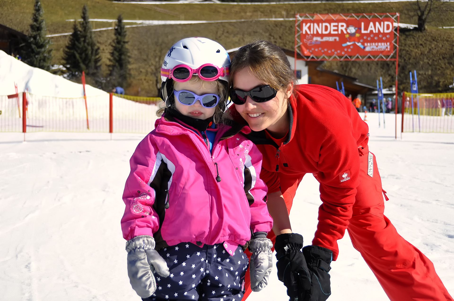 files/upload/kinderland/skischule-alpin-kinderland-skilehrerin-mit-kind-2.jpg